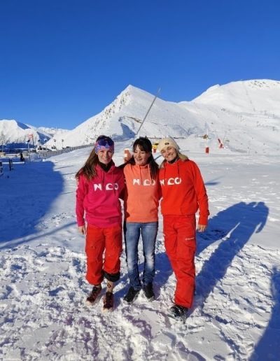Trois femmes portant des sweats N’CO colorés en montagne enneigée